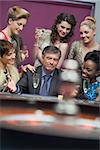 Man surrounded by women accepting of loss in casino