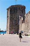 Tourist walking towards Kamerlengo Fortress (Gradina Kamerlengo), Trogir, UNESCO World Heritage Site, Dalmatian Coast, Croatia, Europe