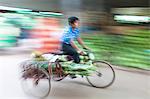 Panned and blurred image to add a sense of movement of a man cycling through Thiri Mingalar market, Yangon (Rangoon), Myanmar (Burma), Asia