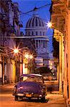 Vintage American car parked on floodlit street with The Capitolio in the background, predawn, Havana Centro, Cuba, West Indies, Central America