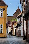 Cobblestone alley in the old town with tower of St. Catharinae Kirke, Ribe, Jutland, Denmark, Scandinavia, Europe