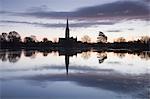 Salisbury cathedral at dawn reflecting in the flooded West Harnham Water Meadows, Salisbury, Wiltshire, England, United Kingdom, Europe