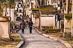 People walking past the gravestones of Pere Lachaise cemetery, Paris, France, Europe