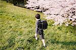 Young boy in a school uniform walking on grass