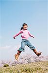Young girl jumping on grassland