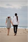 Back View of Couple Walking and Holding Hands on Beach, Sardinia, Italy