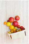 Spilled basket of local organic artisanal tomatos on wooden background, jeffersonville, georgia