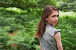 Teenage girl looking over shoulder in  forest
