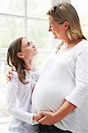 Pregnant mother with teenage daughter by window