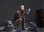 Girl sitting on pile of books reading