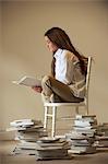 Girl sitting on chair reading book