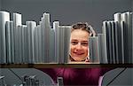 Girl peeking between books on bookshelf