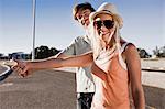 Young couple hitch hiking