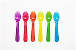 Colourful plastic spoons in a row