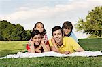 Portrait of family with two children lying on grass