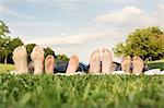 Family with two children lying on grass, focus on feet