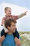 Boy on father's shoulders, pointing