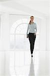 Businesswoman walking in sparse white room