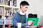 Male student using cell phone at desk