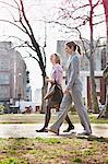 Two businesswomen walking on path in park