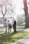 Three businesspeople standing talking in park