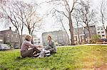 Two businesswomen sitting on grass in park