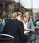 Two businesswomen meeting at outdoor cafe