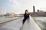 Woman on cell phone on Millennium Bridge, London, England, UK