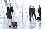 Portrait of businesswoman in airport with suitcase