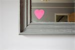 Heart shaped adhesive note on mirror