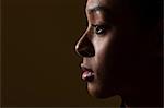 Side view of young woman on black background