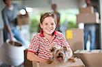 Boy moving house with dog in box