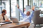 Mature businessman with arms up celebrating