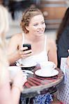 Young woman chatting with friends at a cafe