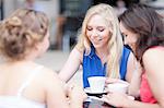 Young women chatting with friends at cafe