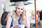 Young woman at cafe wearing head phones