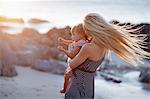 Mother holding daughter on beach