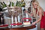 Young women lifting cover off cake stand