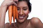 Young woman holding bunch of carrots