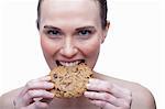 Young woman biting cookie