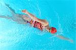 Teenage girl doing front crawl in swimming pool