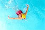 Mature woman doing butterfly stroke in swimming pool