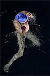 Teenage girl adjusting goggles in swimming pool