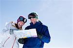 Young couple holding ski map
