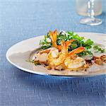 Roasted shrimps and mushrooms with rocket lettuce