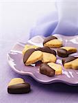 Heart,moon and star-shaped cookies partly coated in chocolate