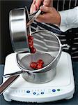 Sieving the strawberries to collect the juice