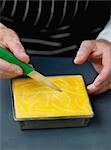 Coating the cake dough with a beaten egg yolk and decorate with curves with the use of a knife