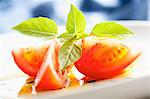 Sliced tomato with olive oil and basil