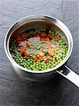 Cooking peas and carrots in a saucepan of water